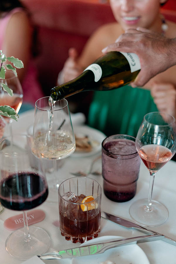 A warm and intimate rehearsal dinner setting, with the couple and their close family and friends gathered around a beautifully decorated table, sharing laughter and toasts.