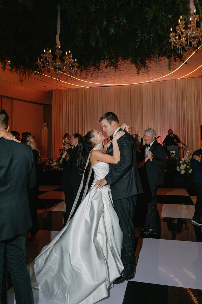 Bride and Groom dancing under twinkling lights at The St. Regis Longboat Key wedding reception with luxury décor and joyful energy.
